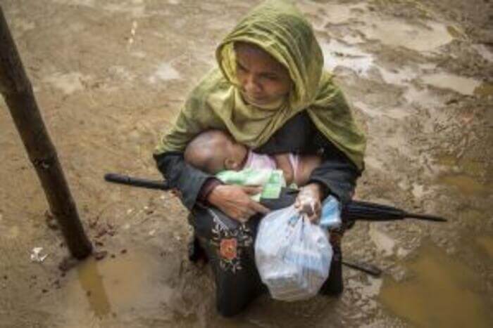 A mother and her child receive fortified biscuits at Kutupalong, the largest refugee camp in the world.